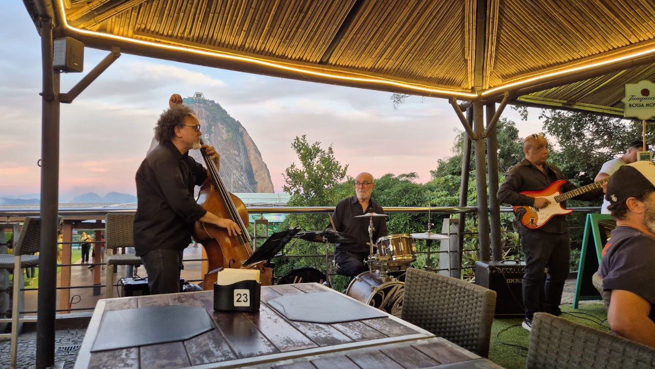 Banda de jazz en vivo en la terraza de Embaixada Carioca con el Pan de Azúcar al fondo al atardecer — Morro da Urca, Río de Janeiro