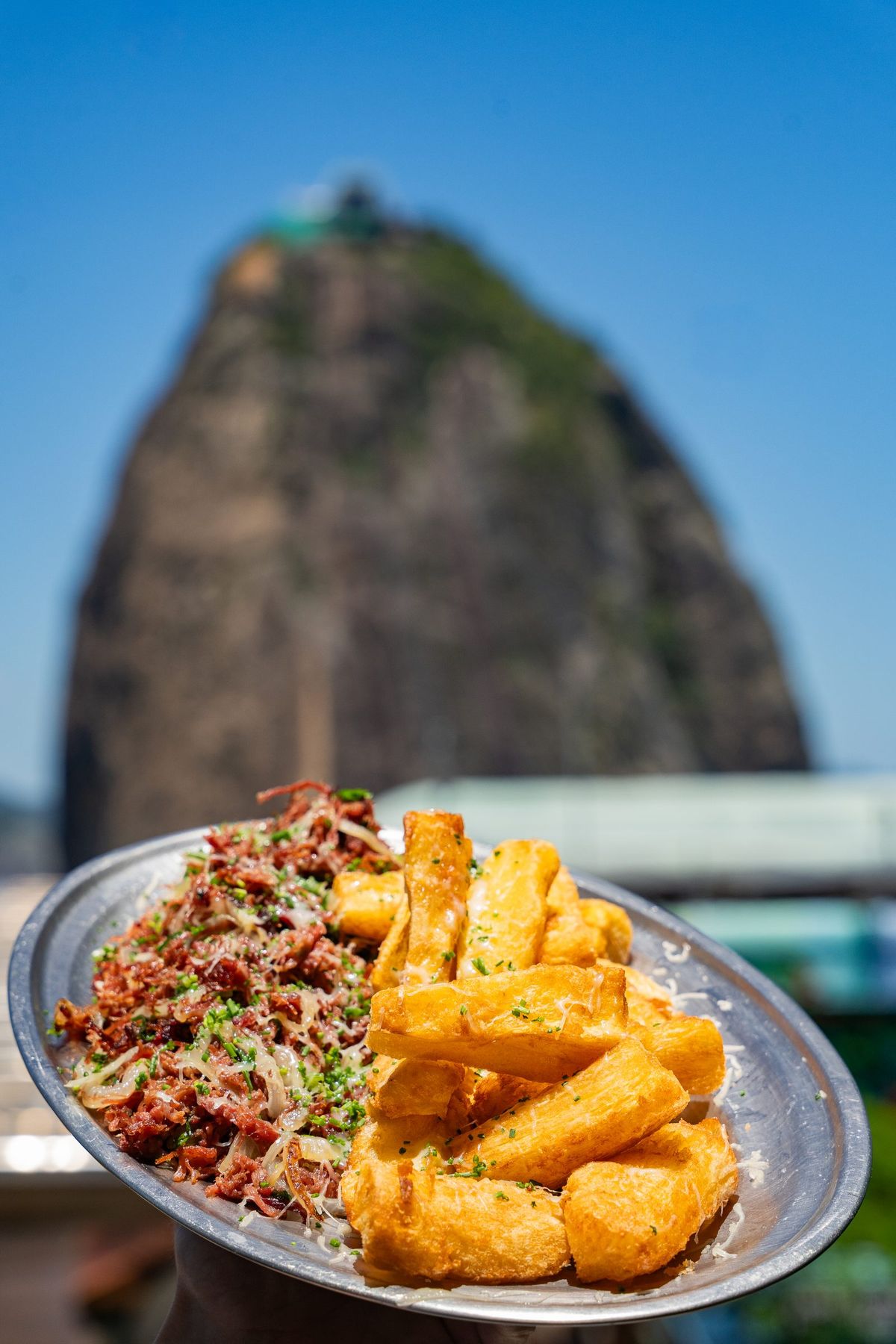Carne seca com mandioca frita e vista para o Pão de Açúcar — prato do almoço na Embaixada Carioca, Morro da Urca, Rio de Janeiro
