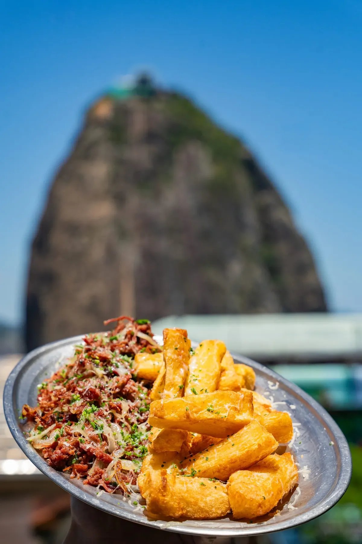 Carne seca con mandioca frita y Pan de Azúcar al fondo — gastronomía brasileña en Embaixada Carioca