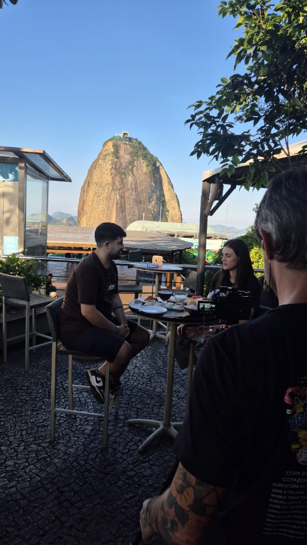 Pareja disfrutando del atardecer en la terraza de Embaixada Carioca con el Pan de Azúcar en primer plano — Morro da Urca, Río de Janeiro