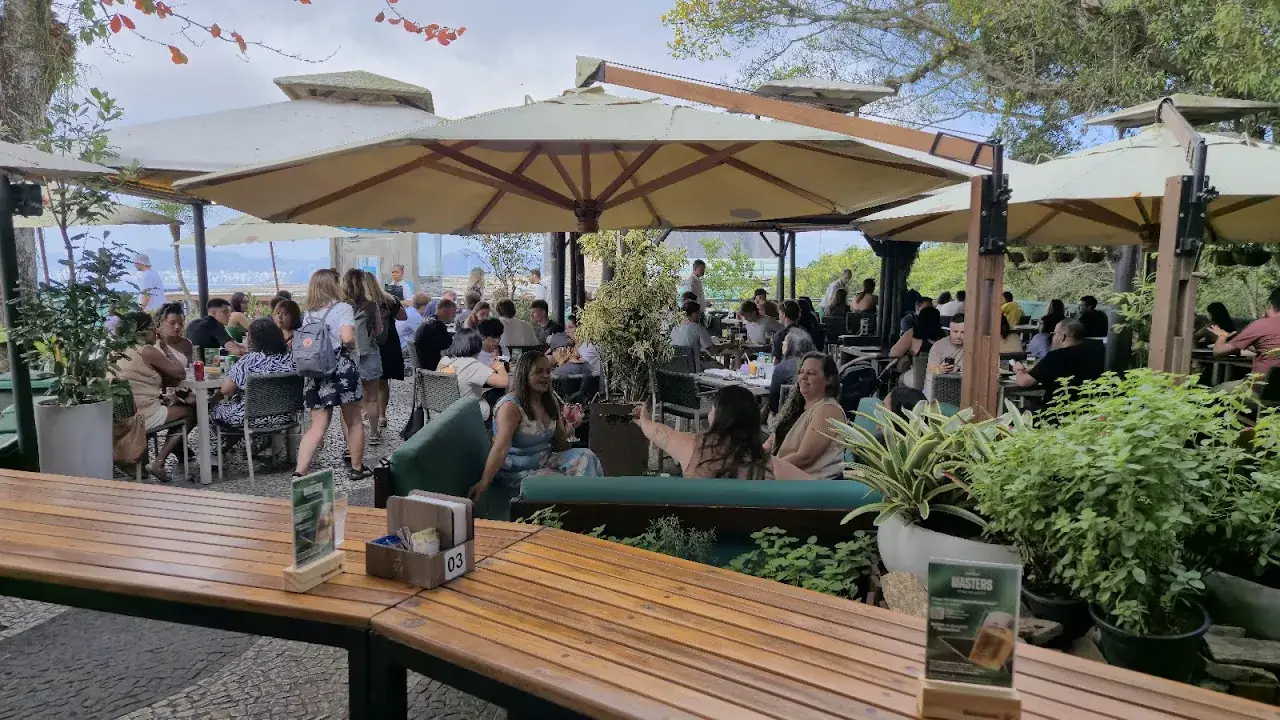 Visitantes nas mesas cobertas do terraço da Embaixada Carioca